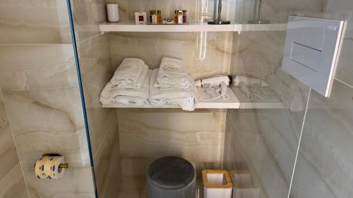 a small bathroom with white towels on a shelf at AC GOLD B&B Boutique Rooms & Suite in Reggio Calabria