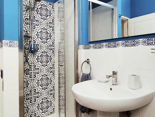 Un baño con lavabo, espejo y ducha. en MareBlu Apartment with patio, en Marina di Castagneto Carducci