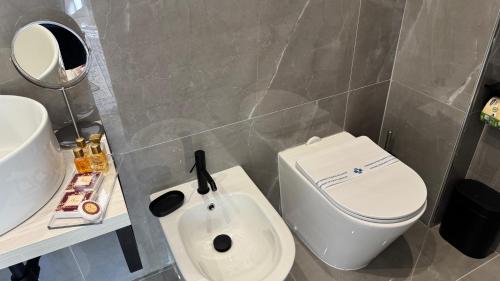 a bathroom with a white toilet and a sink at AC GOLD B&B Boutique Rooms & Suite in Reggio Calabria