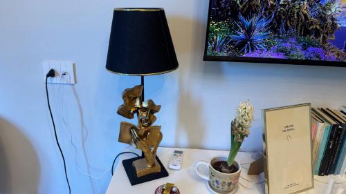 a lamp on a desk with a plant and a picture at AC GOLD B&B Boutique Rooms & Suite in Reggio Calabria