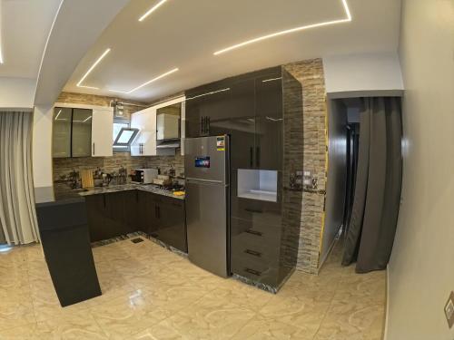 シャルム・エル・シェイクにあるvilla 100C A3のキッチン(黒いキャビネット、ステンレス製の冷蔵庫付)