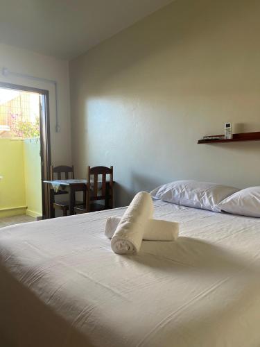 a bedroom with a bed with a towel on it at Pousada garopaba in Garopaba