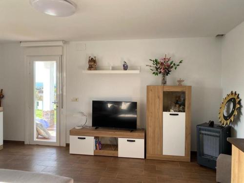 a living room with a television on a table at “Casa abella “ in La Magdalena