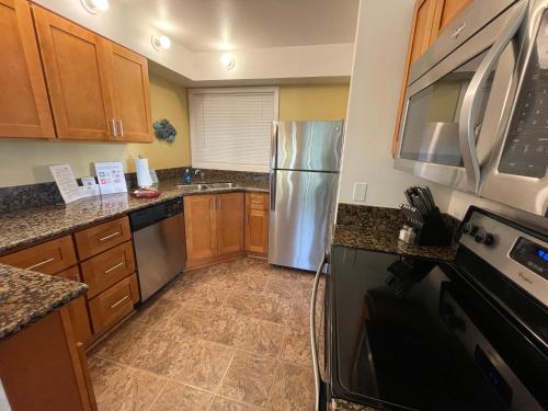 a kitchen with stainless steel appliances and wooden cabinets at Starfish Point in Newport