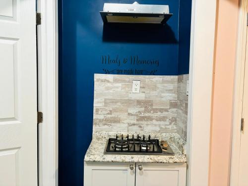 a blue kitchen with a stove and a sink at Sweet Home Georgia Enchanté in Norcross