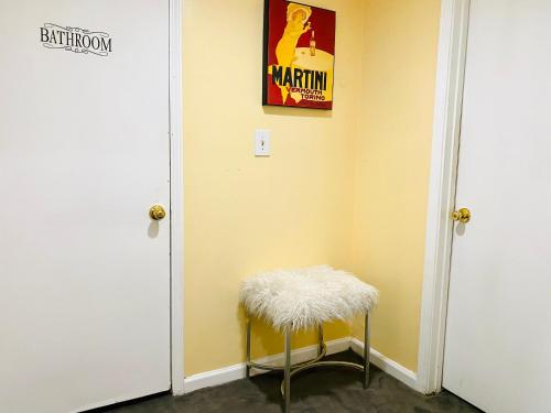a yellow room with a stool and a poster on the wall at Sweet Home Georgia Enchanté in Norcross
