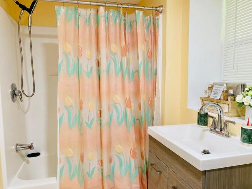 a bathroom with a shower curtain and a sink at Sweet Home Georgia Enchanté in Norcross