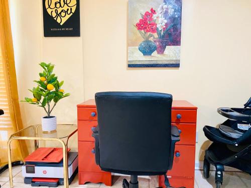 an office with a black chair and a desk and a painting at Sweet Home Georgia Enchanté in Norcross
