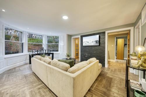a living room with a couch and a tv at Stylish 3-Bedroom Apartment in Central Glasgow in Glasgow