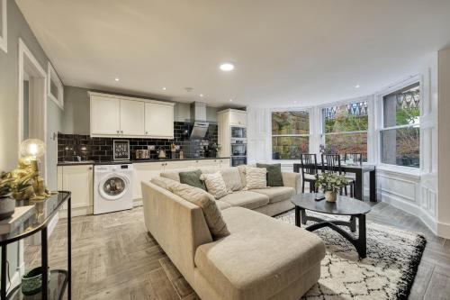 a living room with a couch and a kitchen at Stylish 3-Bedroom Apartment in Central Glasgow in Glasgow
