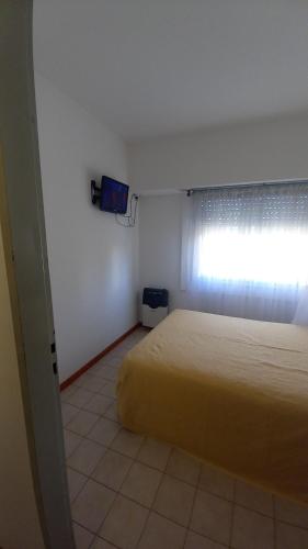 a small bedroom with a bed and a window at Noche Serena in Puerto Madryn