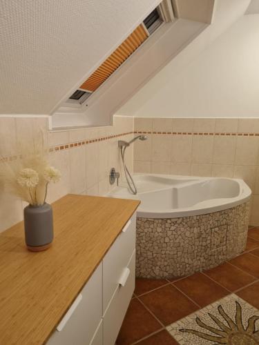a bathroom with a bath tub and a sink at Wellnesshaus Dorfblick mit Outdoor-Jacuzzi und Infrarotkabine in Dreis-Brück