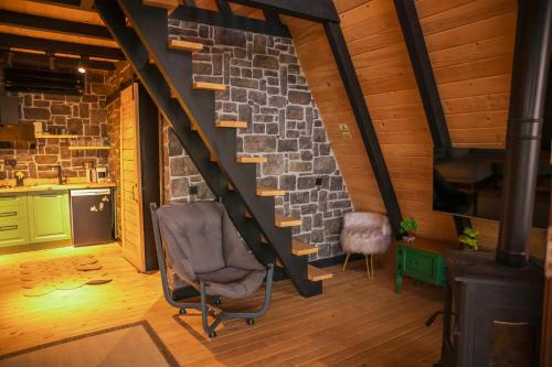 a living room with a stone wall and a chair at Hill House Bungalov in Sapanca
