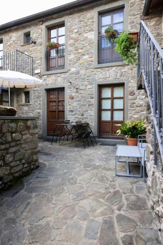 a patio with chairs and tables in front of a building at Agriturismo Montagna Verde Apella in Licciana Nardi