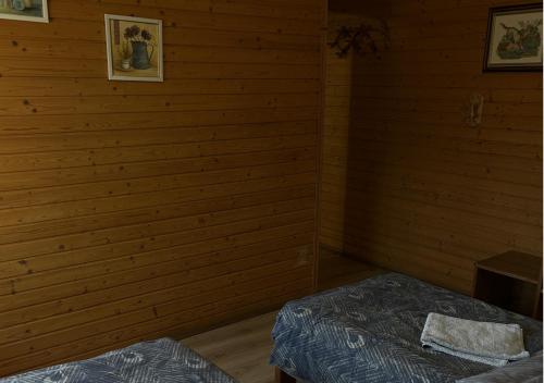 a room with two beds in a wooden wall at Готель Могул in Vorokhta