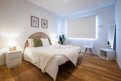 a white bedroom with a bed and a television at Recanto da Ilha in Lagoa