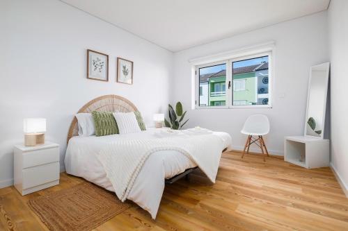 a white bedroom with a large bed and a window at Recanto da Ilha in Lagoa