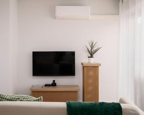 a living room with a couch and a flat screen tv at Recanto da Ilha in Lagoa