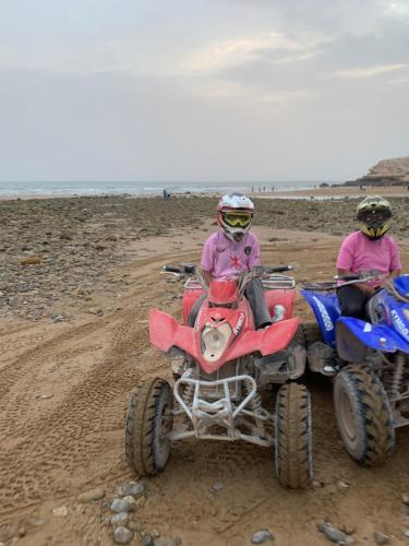 two people are riding on atvs on the beach at Domaine Alya in Sidi Bibi