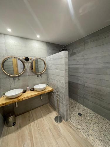 a bathroom with two sinks and two mirrors at La Casa Del Pelao in Solanilla