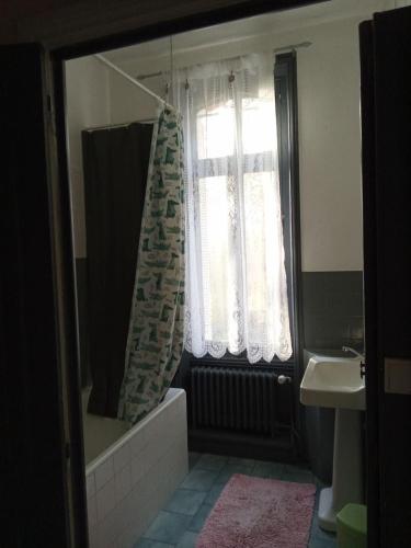 une salle de bain avec une baignoire, un lavabo et une fenêtre dans l'établissement Chambre dans maison bourgeoise, à Airvault