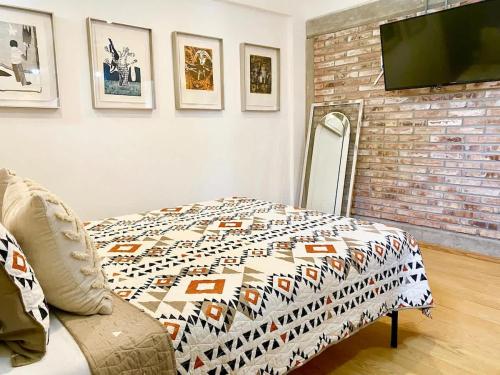 a room with a bed and a television on a wall at Edgy Vibes Studio in Tijuana in Tijuana