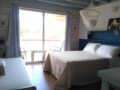 a bedroom with a bed and a large window at La Pedrasanta in La Pedrera