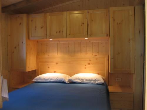 エントラックエにあるCampeggio Valle Gessoのベッドルーム1室(青いベッド1台、木製キャビネット付)