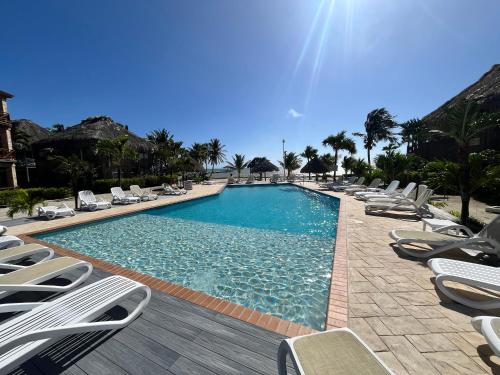 a large swimming pool with lounge chairs and the sun at Captain Morgan's Retreat in San Pedro