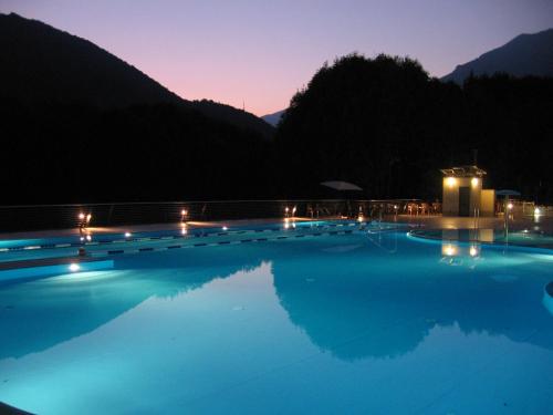 una piscina por la noche con luces encendidas en Campeggio Valle Gesso, en Entracque