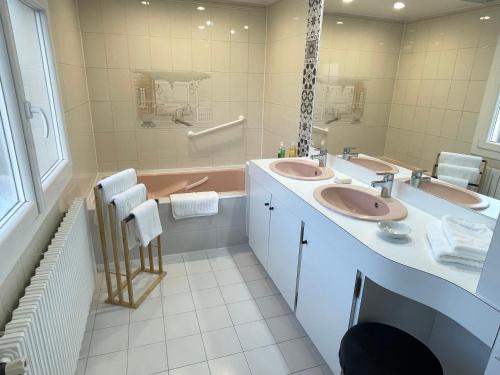 une salle de bain avec deux lavabos et une baignoire dans l'établissement Appartement cosy dans une maison de caractère, à Tallard