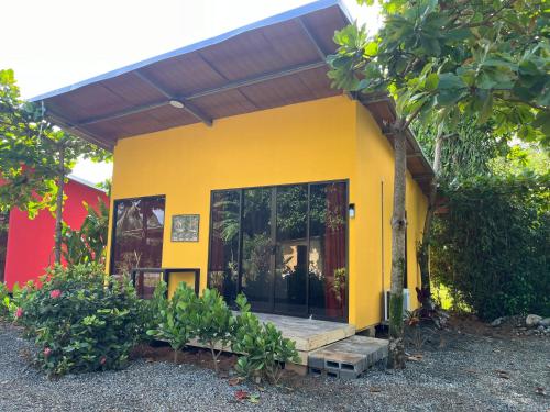 a yellow house with a large glass door at Uvita Oasis Retreat with Villa Cabins and Apartment in Uvita