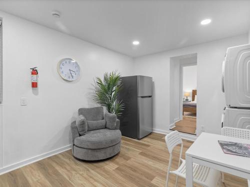 a living room with a chair and a refrigerator at Lawrenceville Central !2 Stylish and Quiet One Bedroom Apartment with Free Street Parking in Pittsburgh