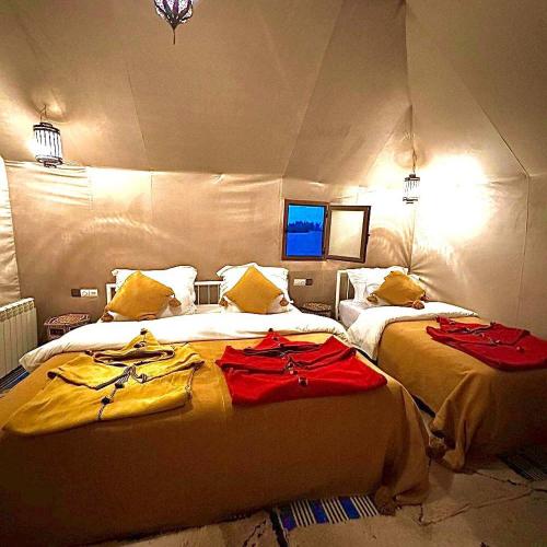 a bedroom with two beds in a tent at Merzouga Horizon Luxury Camp in Merzouga
