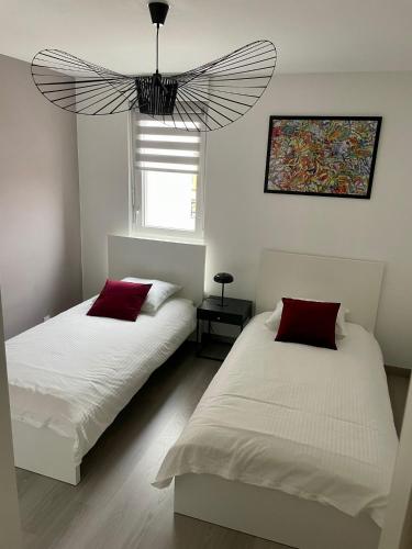 une chambre avec deux lits et un lustre dans l'établissement A few steps from BASEL with Balcony and free private parking, à Saint-Louis