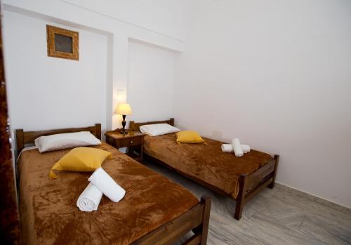 a bedroom with two beds with towels on them at Smarula Villa in Firostefani