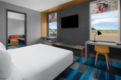 a bedroom with a bed and a desk with a computer at Aloft Broomfield Denver in Broomfield