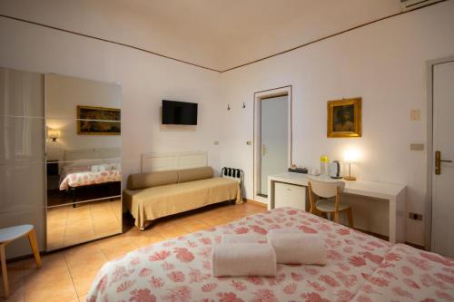 a bedroom with a bed and a desk and a bed at Althea Rooms in Florence