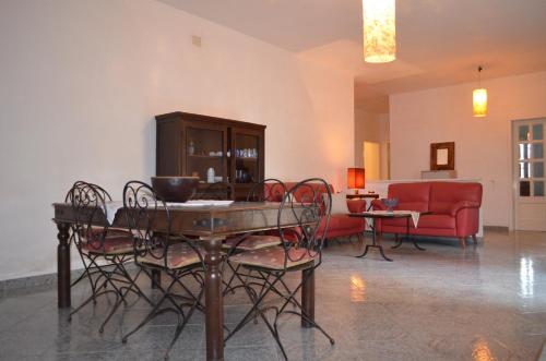een woonkamer met een tafel en stoelen en een bank bij Villetta Summer in Porto Cesareo