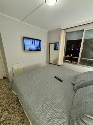 a bedroom with a bed and a tv on the wall at DEPARTAMENTO APOLO PUNTA DEL ESTE DEPTO 201 SEGUNDO PISO sobre CALLE PRINCIPAL GORLERO in Punta del Este