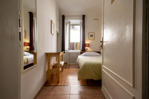 a hallway with a bedroom with a bed and a window at Althea Rooms in Florence