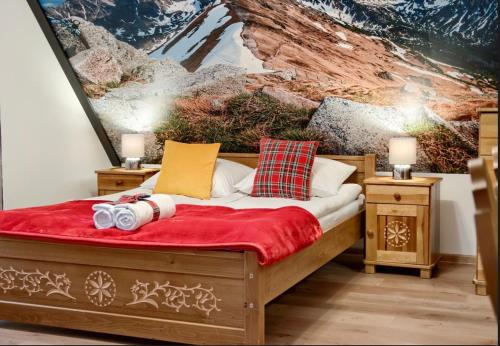 a bedroom with a bed with a red blanket and pillows at DW Na Równi Białka Tatrzańska in Białka Tatrzanska