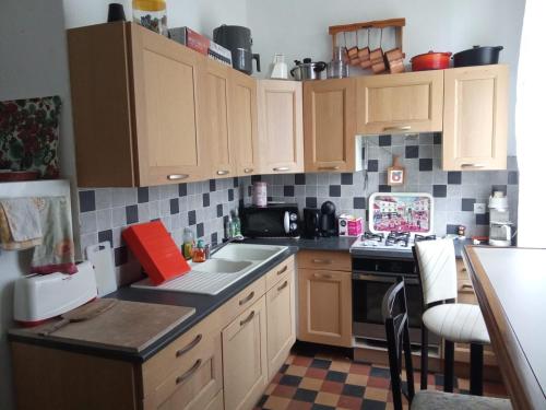 une cuisine avec des armoires en bois et un four à plaques de cuisson dans l'établissement Chambre dans maison bourgeoise 2, à Airvault