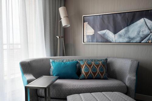 a living room with a couch and a painting at Courtyard by Marriott Denver Airport in Denver