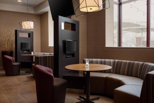 a restaurant with a couch and a table and chairs at Courtyard by Marriott Denver Airport in Denver
