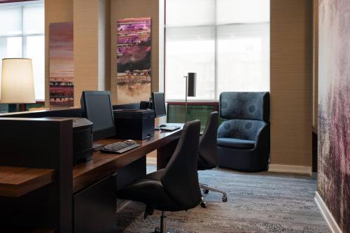 an office with a desk with a computer and a chair at Courtyard by Marriott Denver Airport in Denver