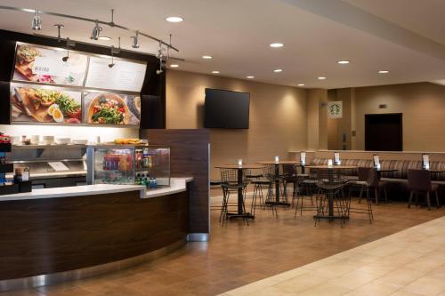 a restaurant with a bar with tables and chairs at Courtyard by Marriott Denver Airport in Denver