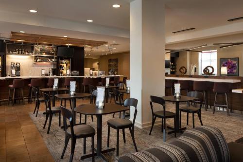 a restaurant with tables and chairs and a bar at Courtyard by Marriott Denver Airport in Denver