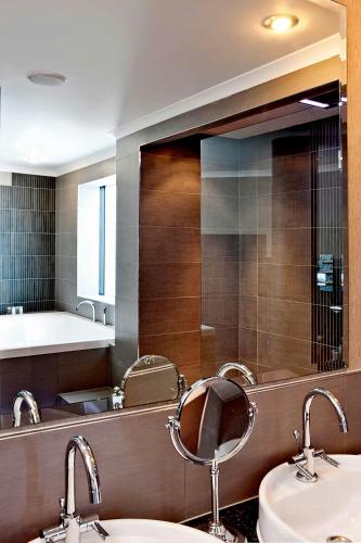 a bathroom with two sinks and a large mirror at The Glasshouse, Autograph Collection in Edinburgh