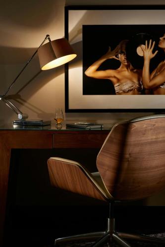 a desk with a chair and a picture of a woman at The Glasshouse, Autograph Collection in Edinburgh